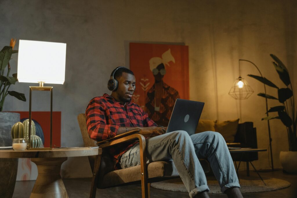 African American man working on a laptop indoors, embracing remote work lifestyle.